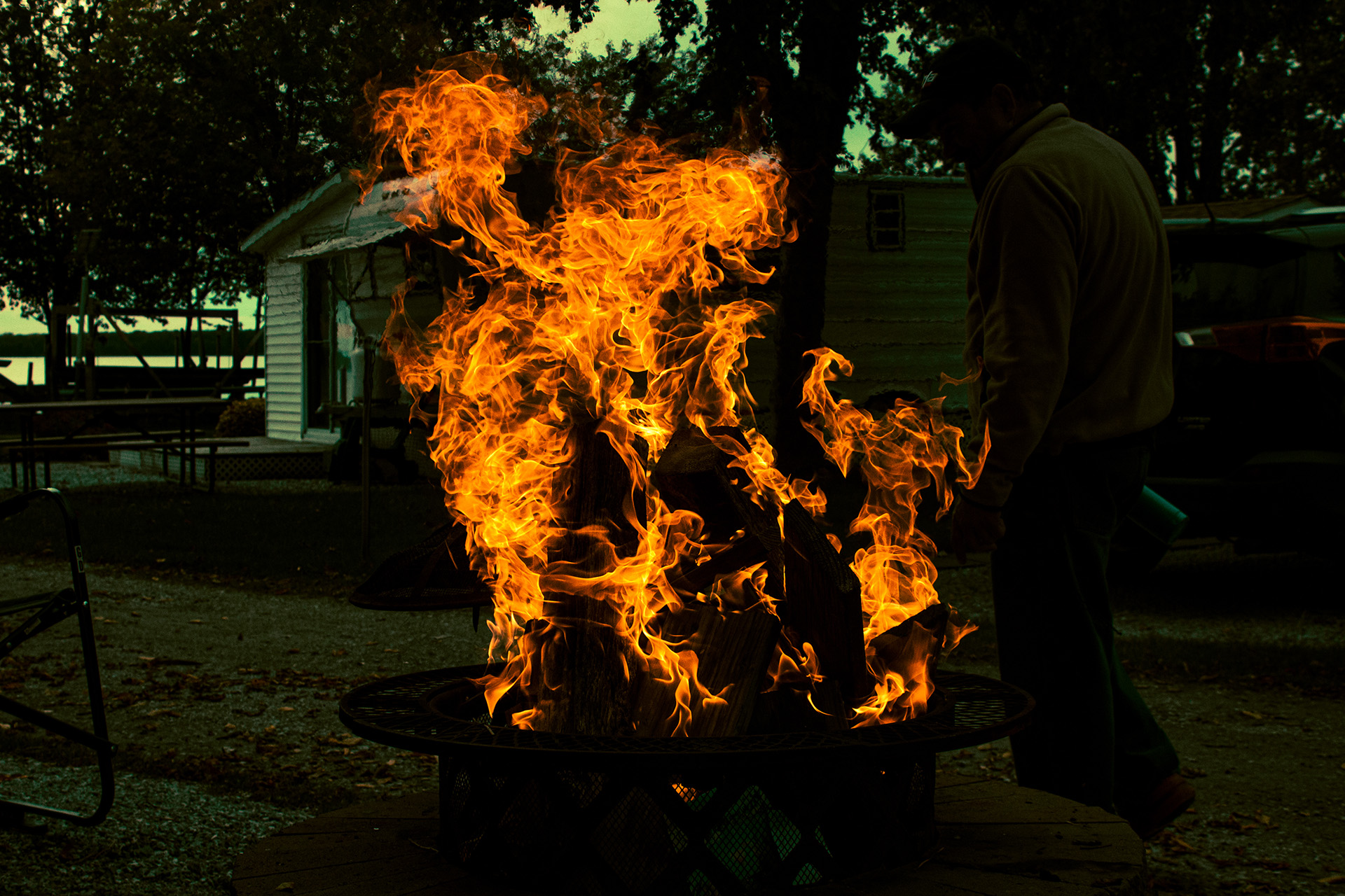 A man walks past a firepit