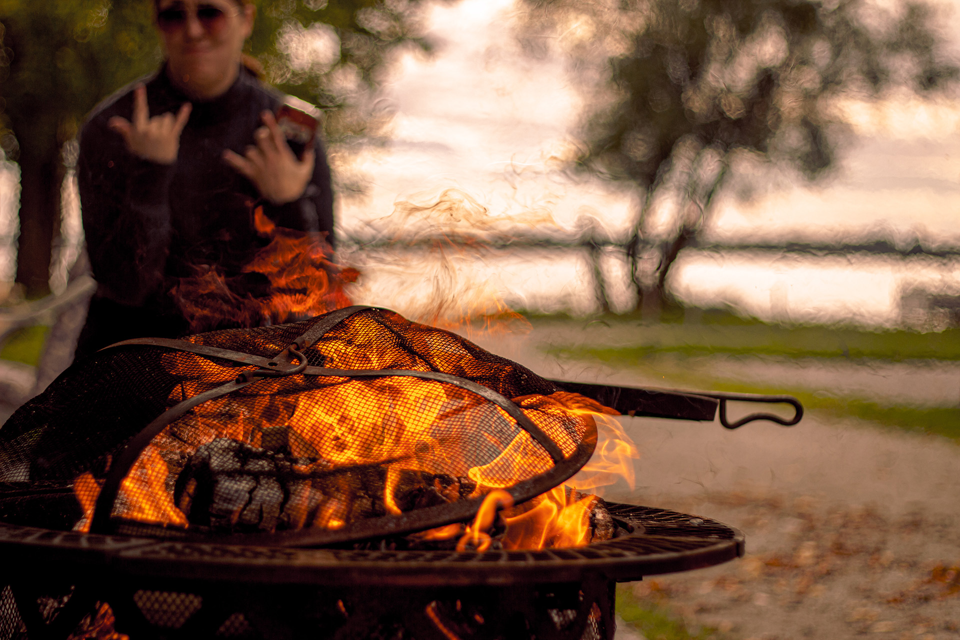 My sister standing behind a firepit